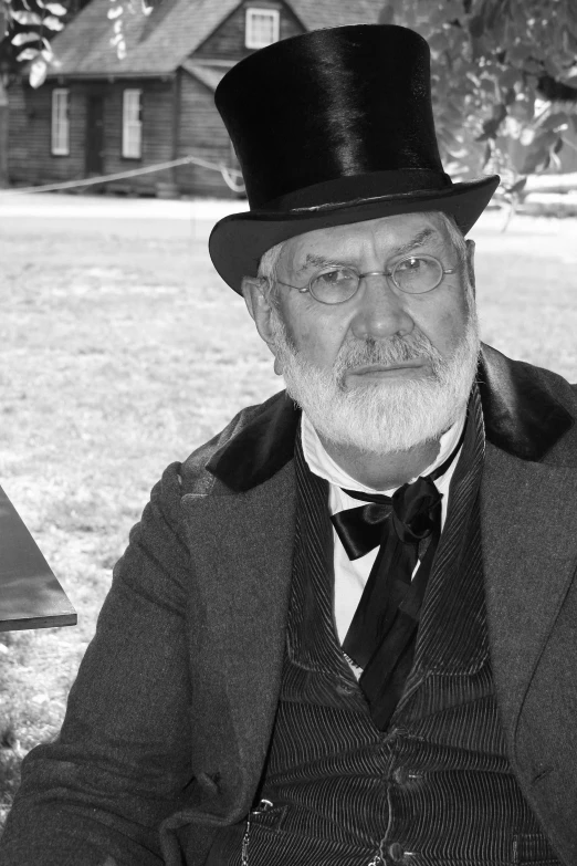 an older man in top hat, jacket and glasses