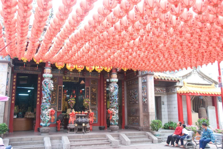 an entrance to a temple adorned in red and pink lanterns