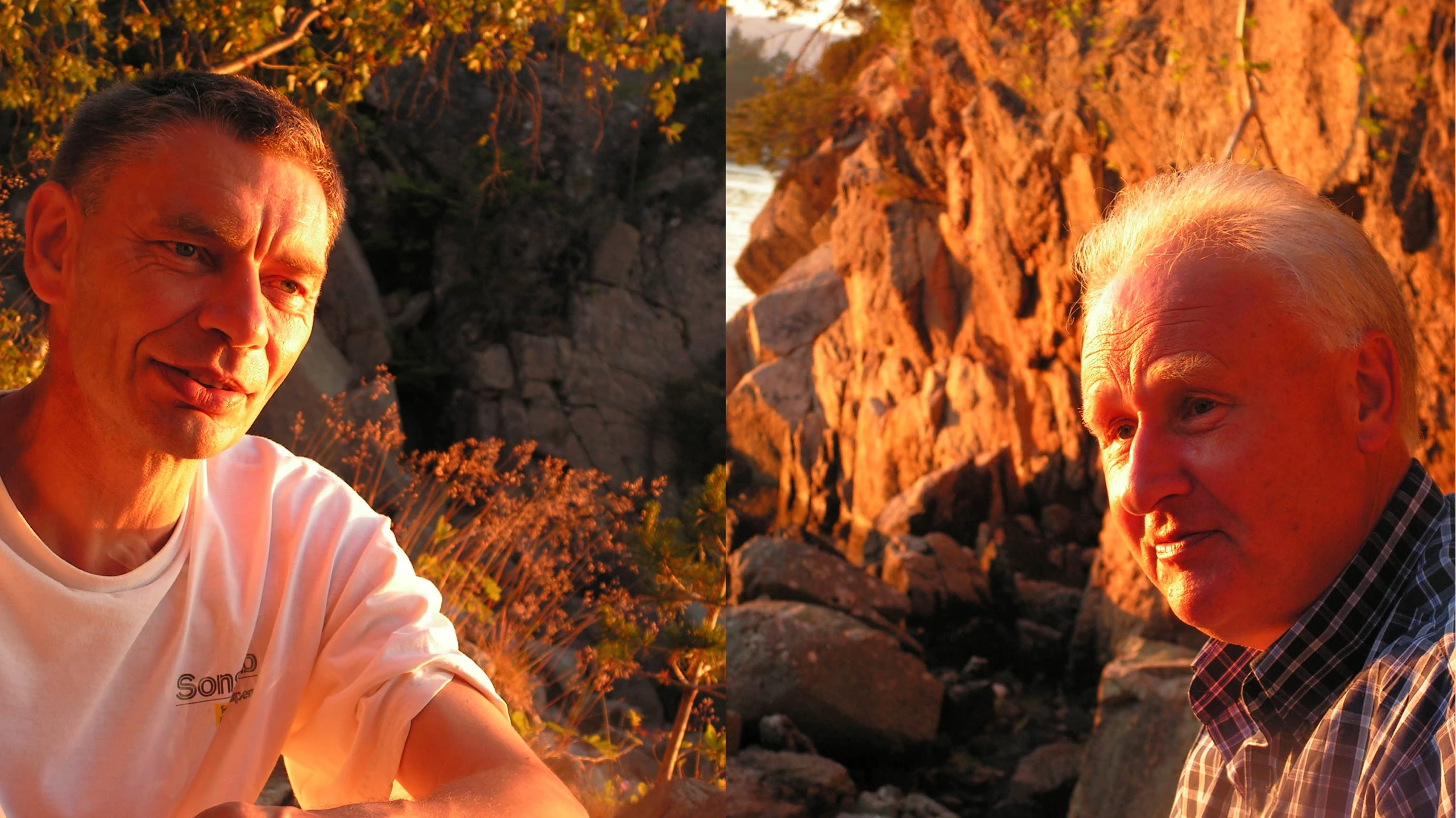 two men siting next to each other near rocks