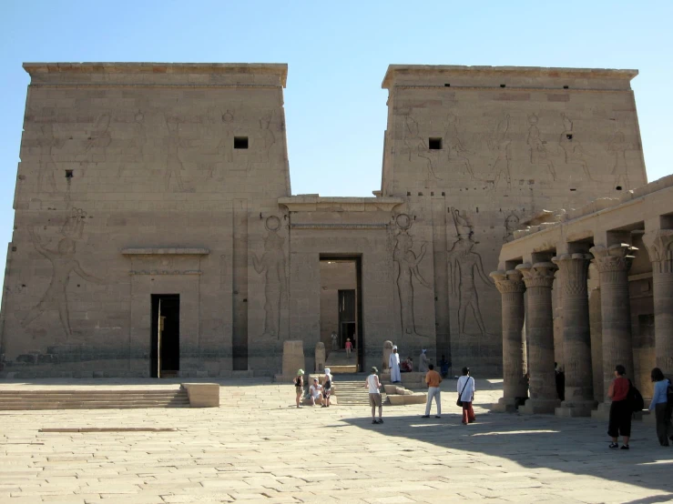 people walk around in front of some very large structures