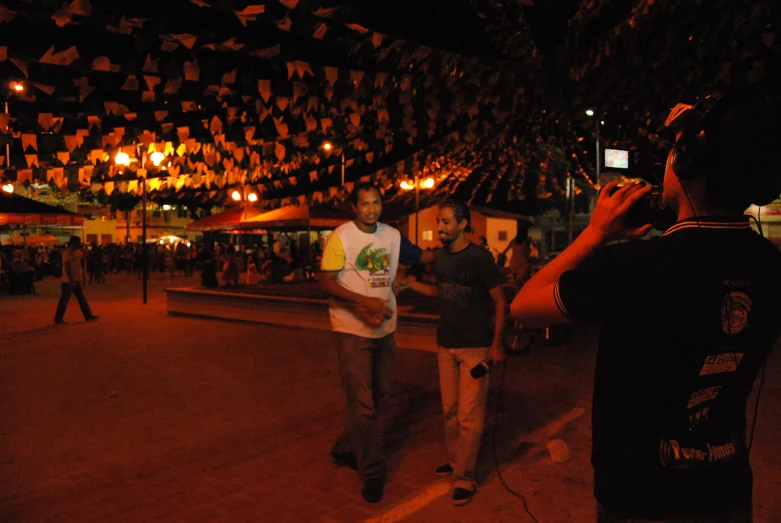 two men standing inside a building with many lights on