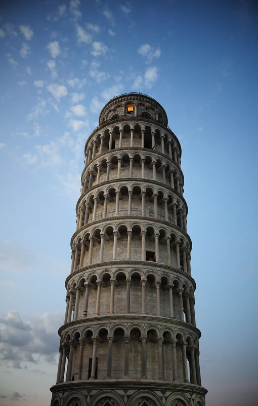 the tower has an interesting shape and features a bright yellow light