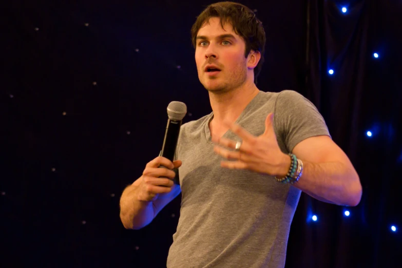 a man standing with his hands up while speaking