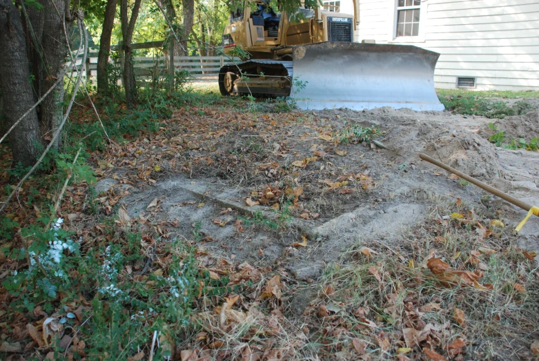 a bulldozer in front of a house and a driveway