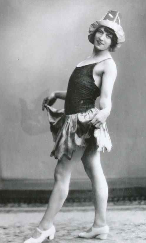 a woman in a dress and hat standing