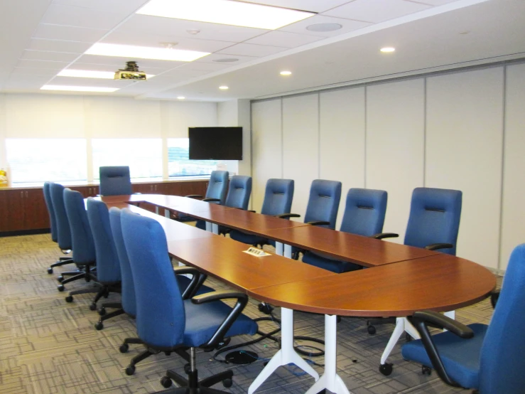 a conference room with long tables and blue chairs