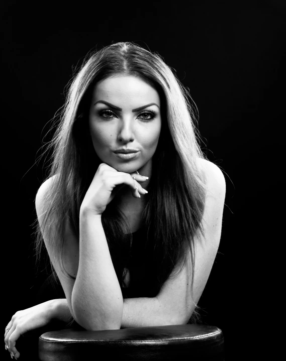 a woman sits at a table posing for the camera