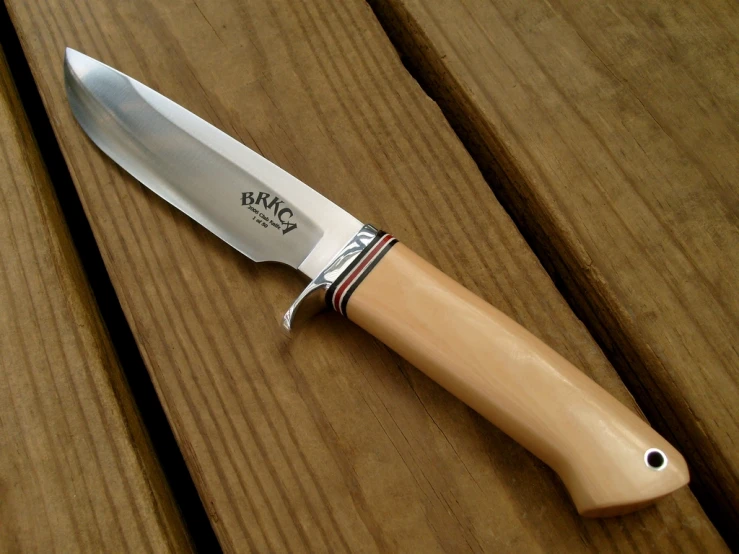 a knife is laying on a table with a wood handle