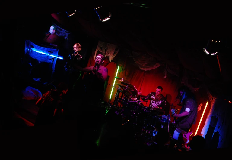 band performing in darkened room with spotlights in background