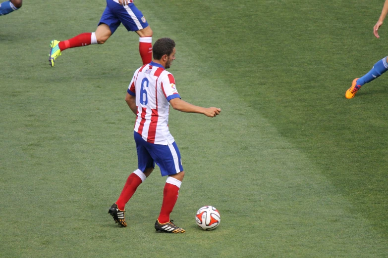 a man kicking a soccer ball around a field