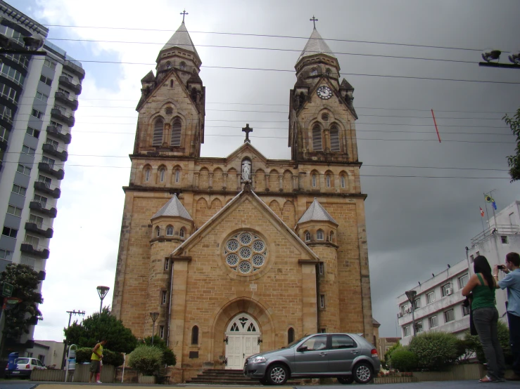 two people standing in front of an old church