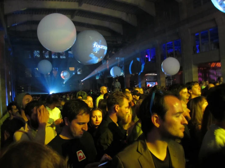 a large group of people in the night with balloons