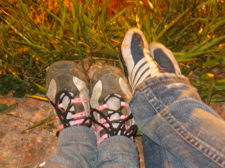 a pair of feet, with shoes and a pink striped sock on