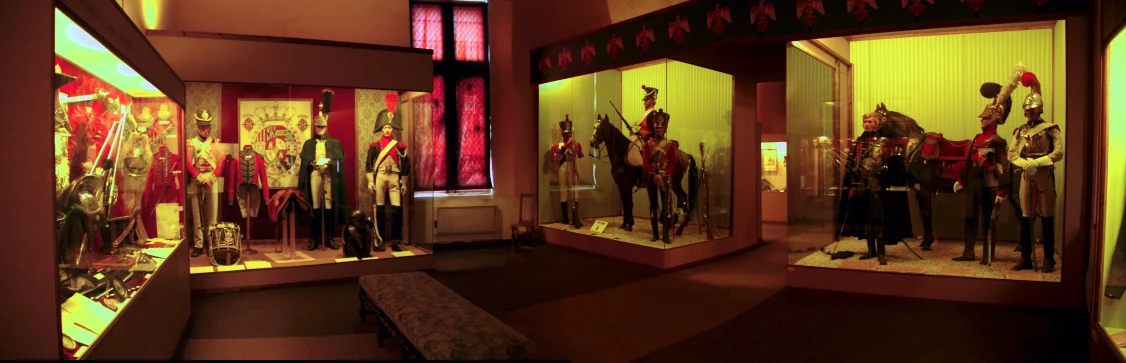 an old fashioned glass shop window display featuring war uniforms and war horses