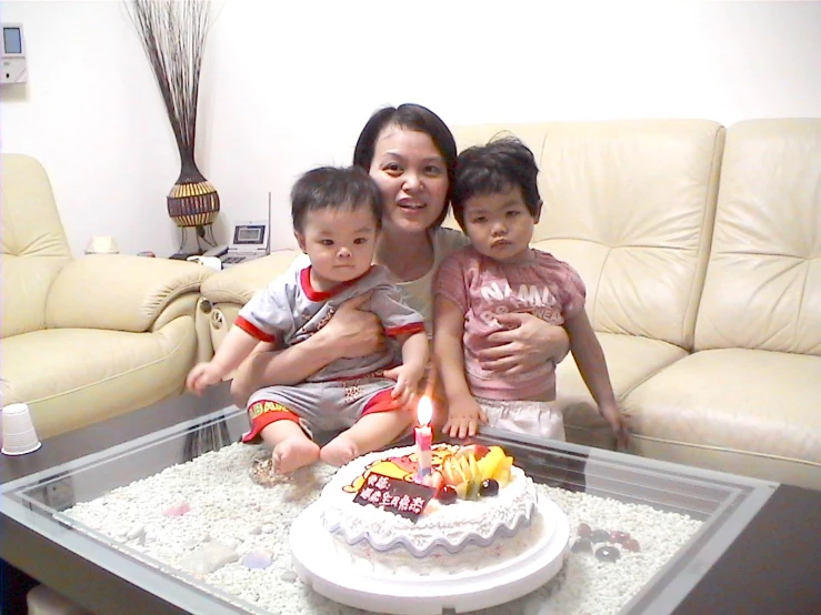 the woman and two children are in front of a cake