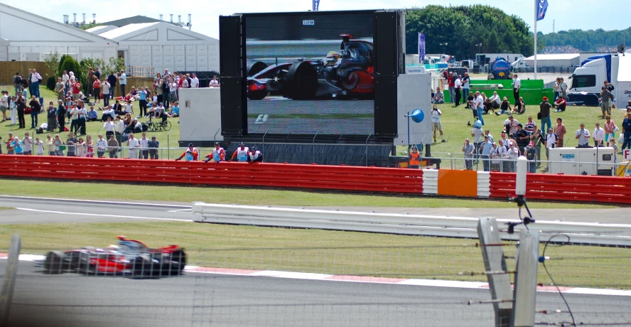 a formula car racing around the track during a large event