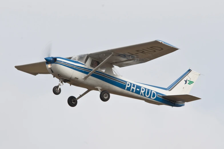 a blue and silver plane flying in the sky