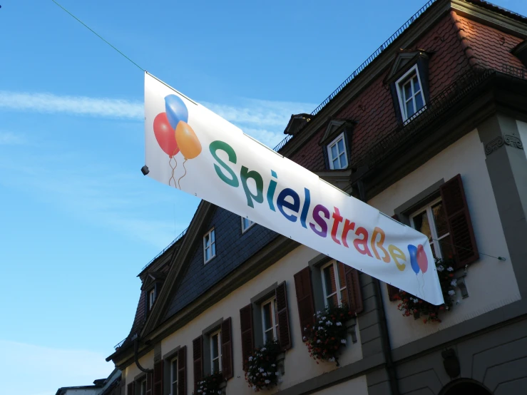 the sign for a business called epieltstrass hangs from a line of brick houses