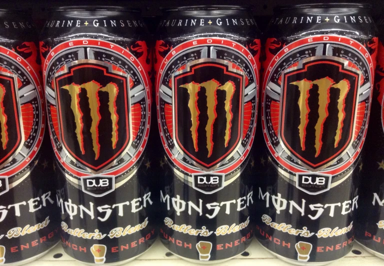 a group of monster drinks sitting on a shelf