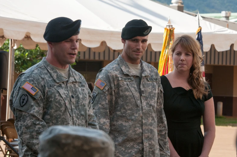 soldier and woman are in uniform standing with others