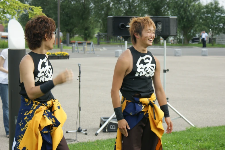 two young men are dressed in costumes on the sidewalk