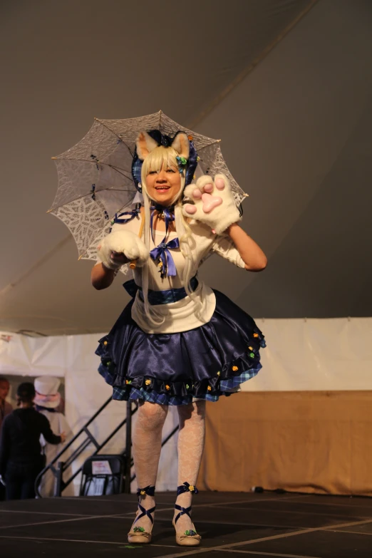 a woman in costume is walking on the runway