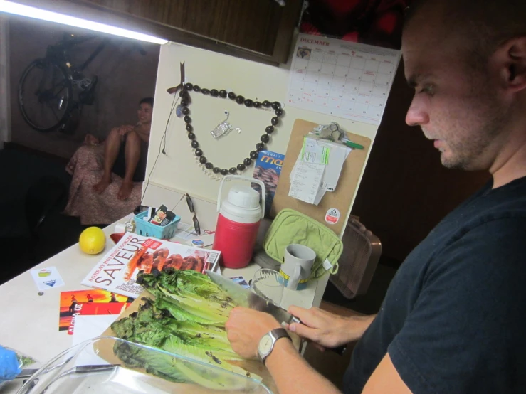 a man cuts up broccoli on a counter top