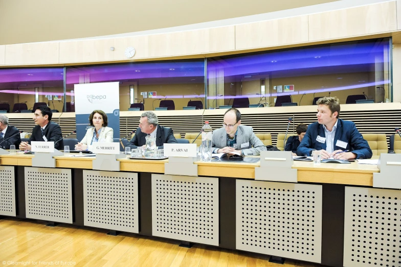 five men at a table in front of three women and one man