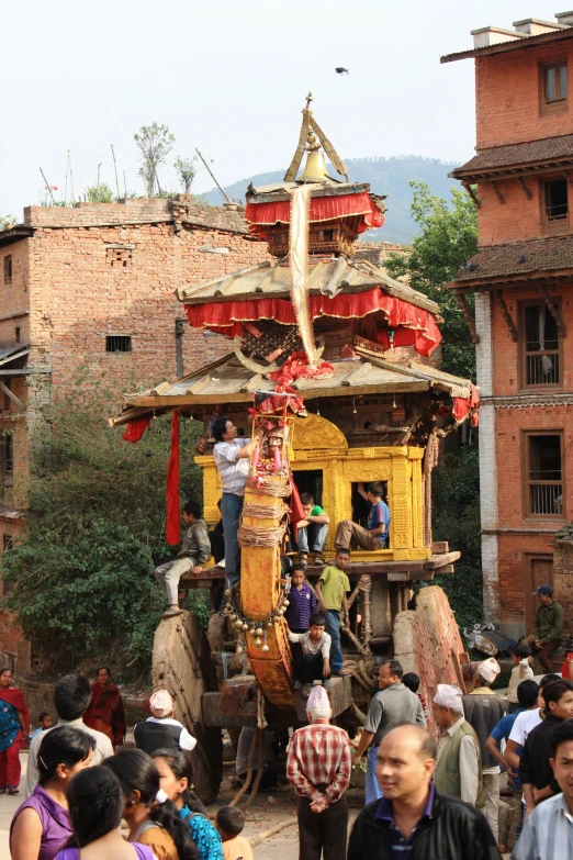 people crowd around as one of them rides in an elephant