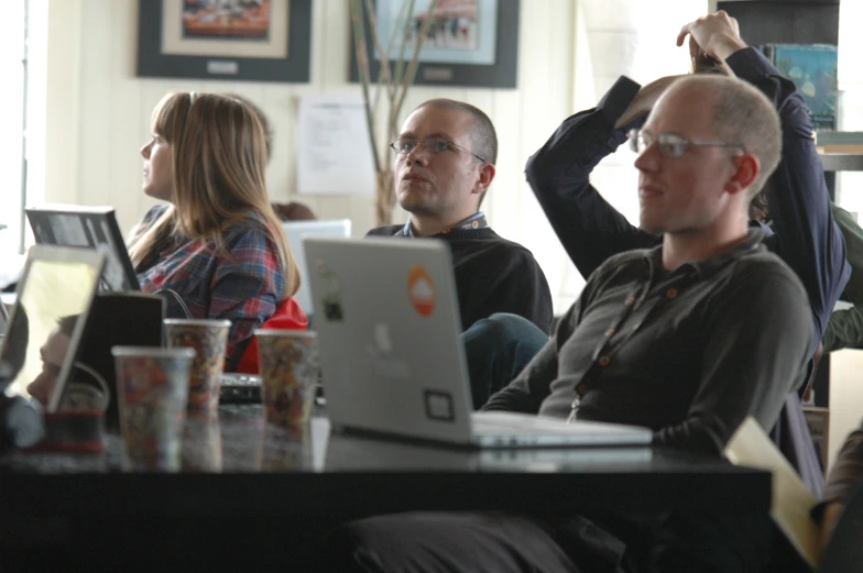 people at an office sitting on couch using laptops