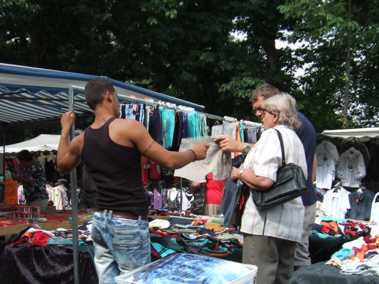 a couple is standing in front of a store selling clothing