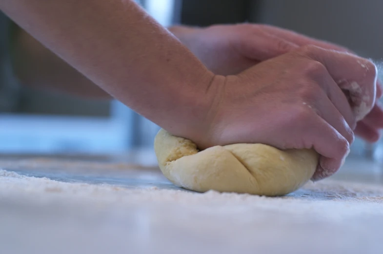 the person kneading bread on the counter