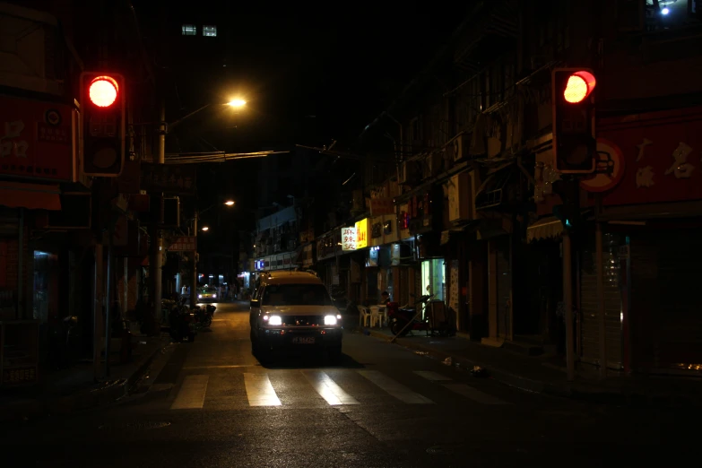 a car driving down the middle of a street at night