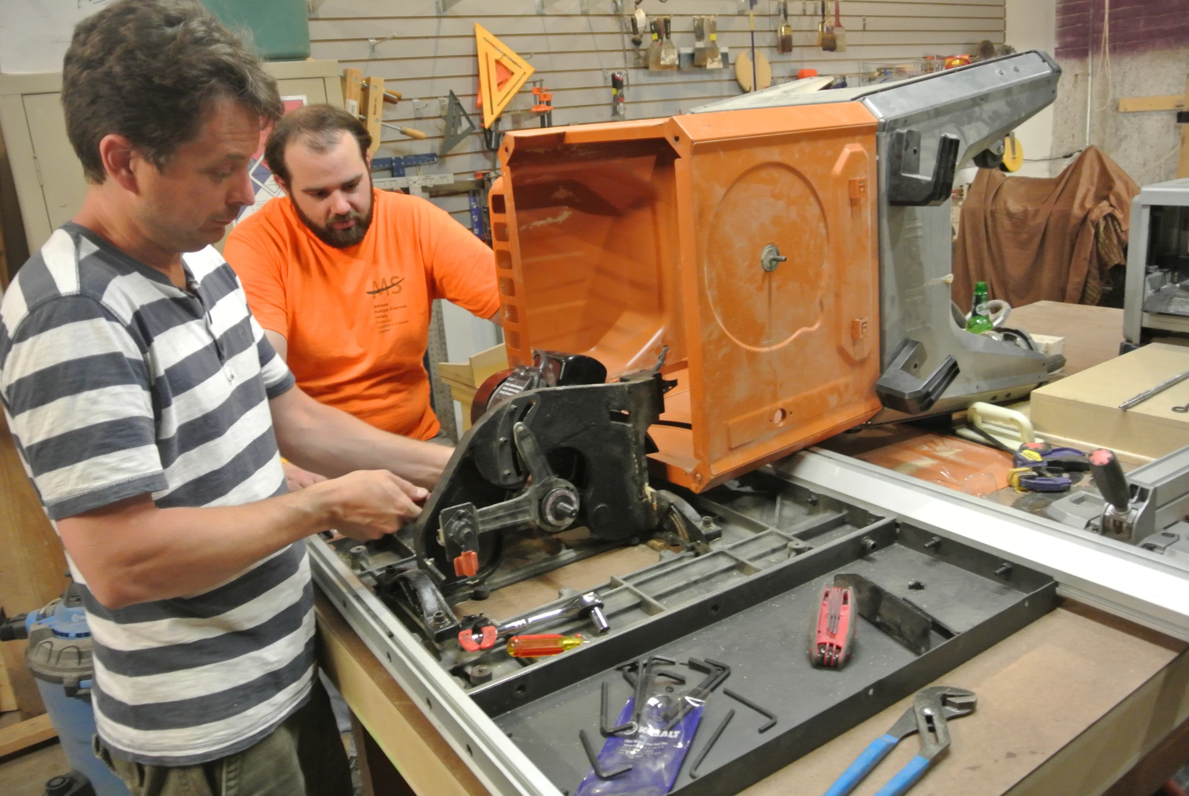 two men working on a project in a shop