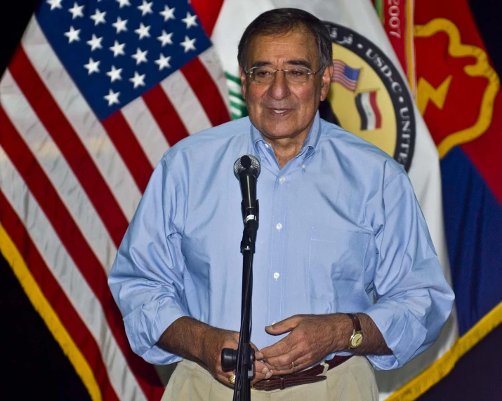 a man standing in front of american and us flags