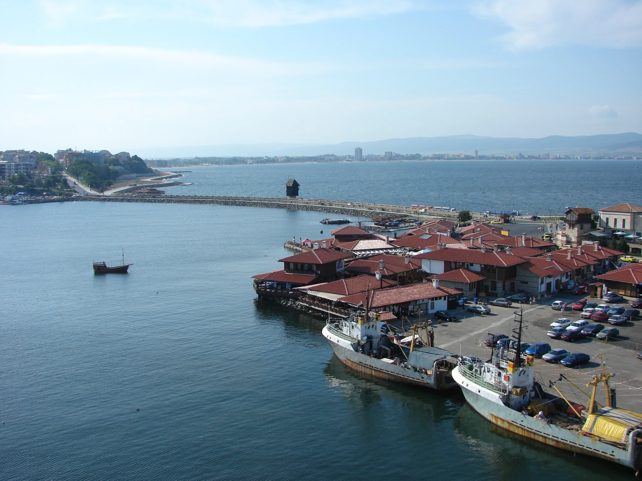 a bunch of boats docked at a pier in the ocean