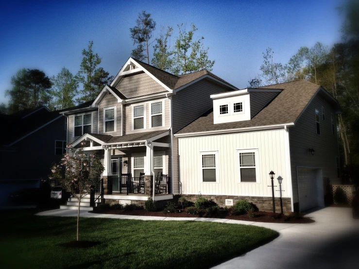 a house in front of some trees on a sunny day