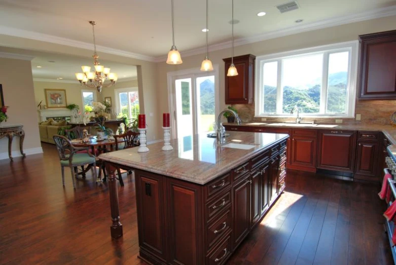 a large kitchen has hardwood flooring and a wooden island
