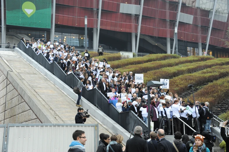 many people walk and are carrying onto some steps