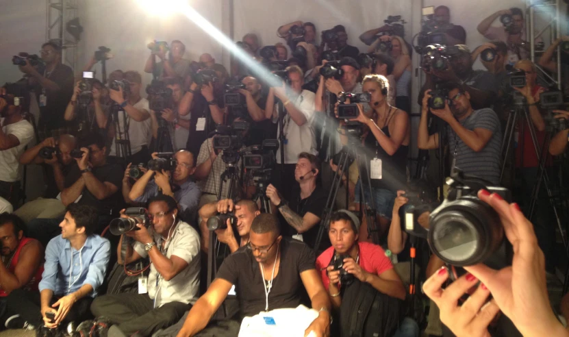 a group of people are standing and taking pictures with camera equipment