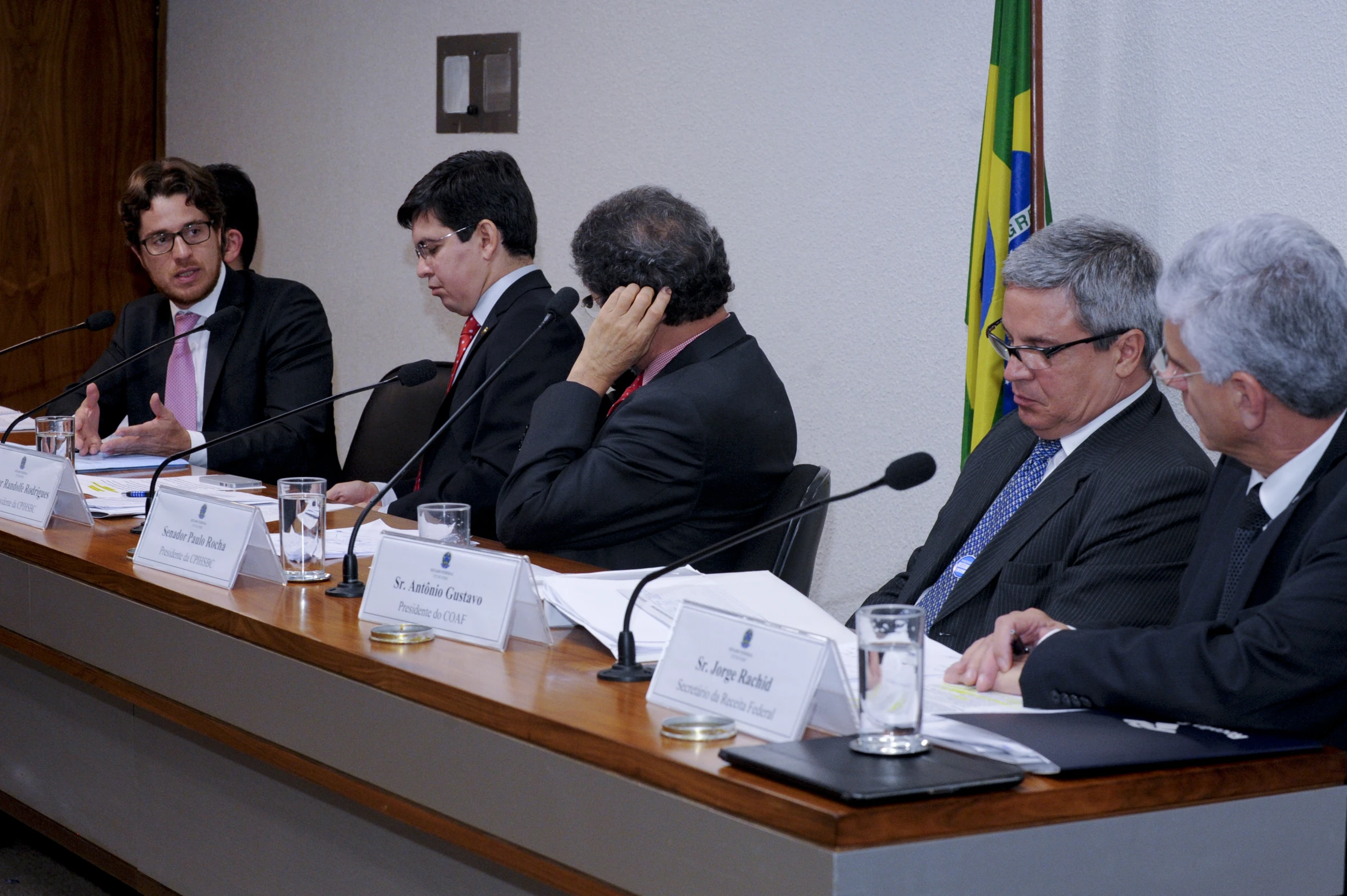 five people sitting at a table during a meeting