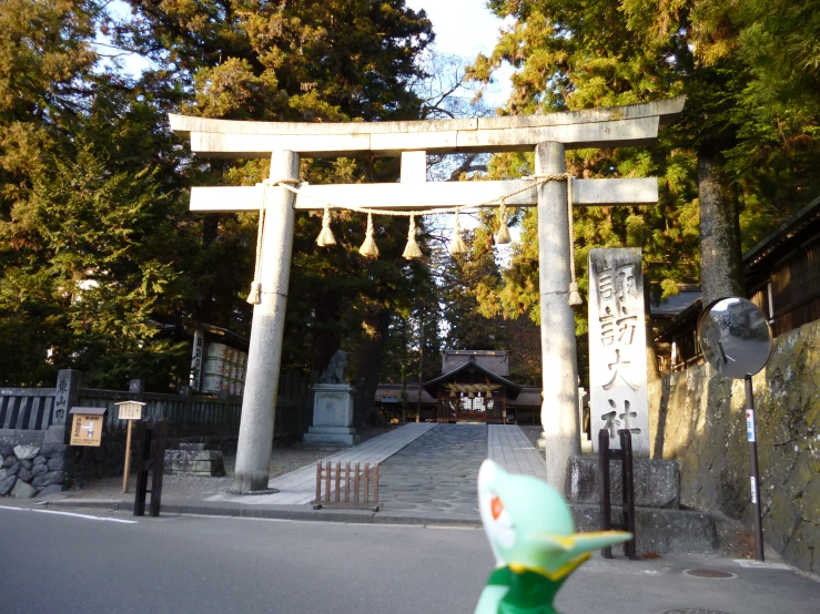 a sculpture with bells hanging from it near trees