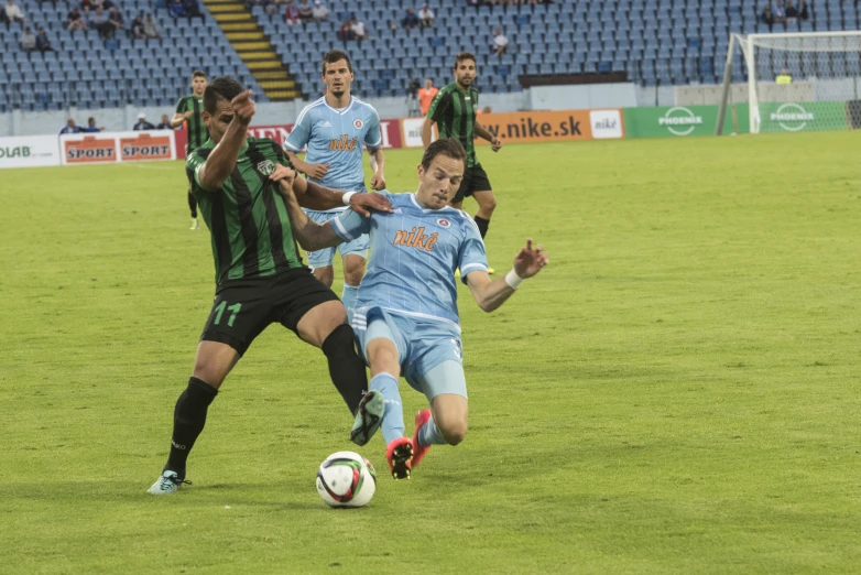 two men are playing soccer with one holding the ball