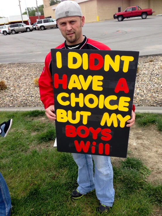 man holding a protest sign saying i didn't have a choice, but my boys will