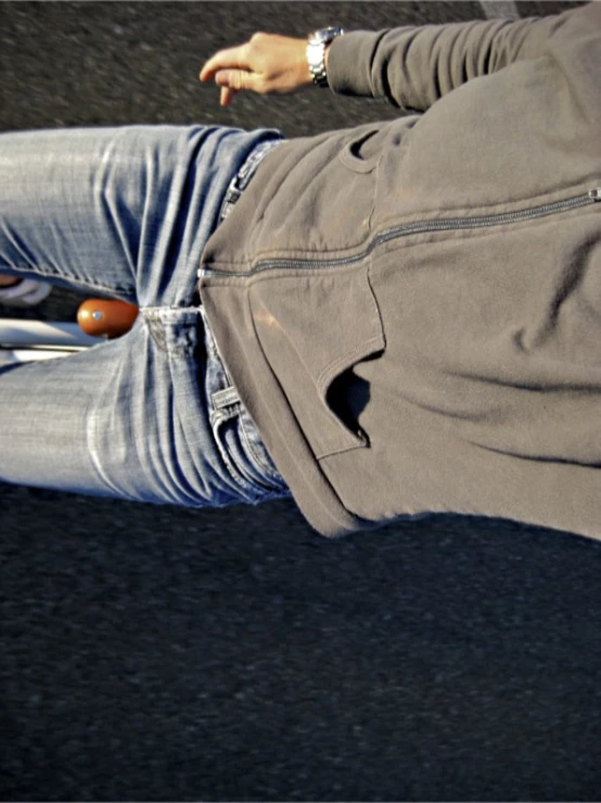 a man wearing a gray jacket and jeans