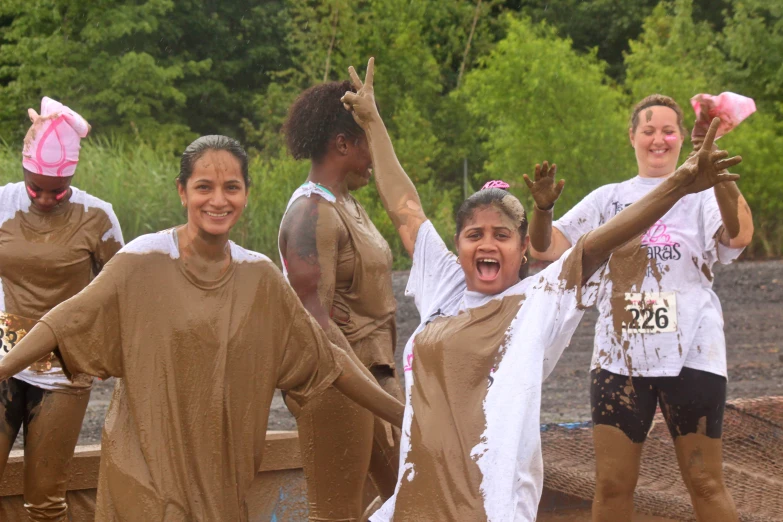 a group of people in mud costumes are running