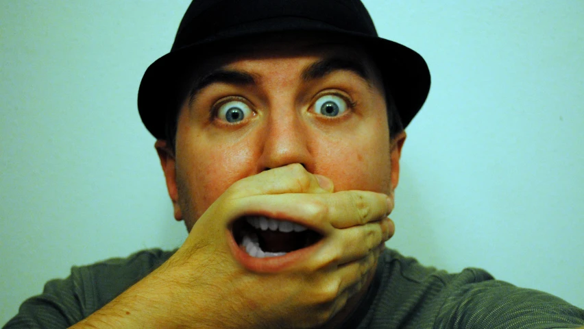 man with surprised expression and hat making face
