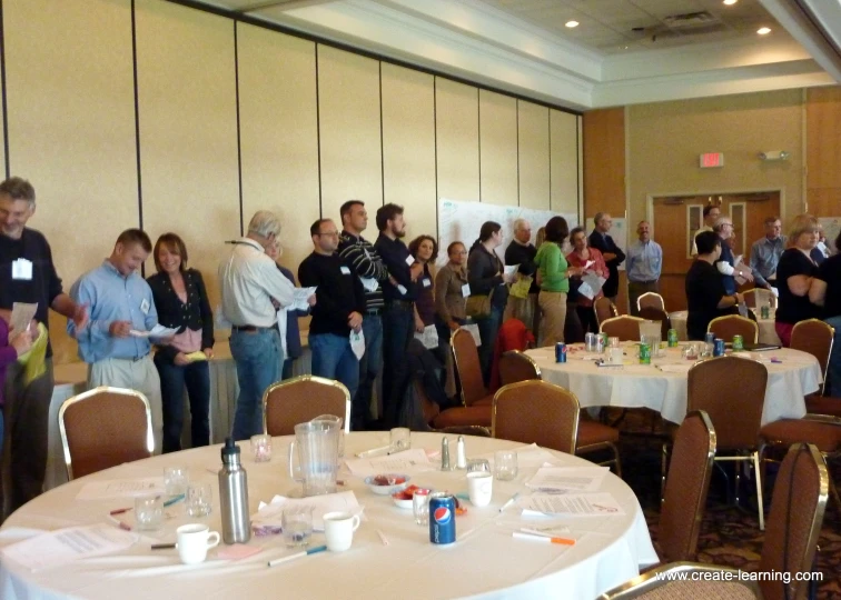 a group of people standing in a room full of tables