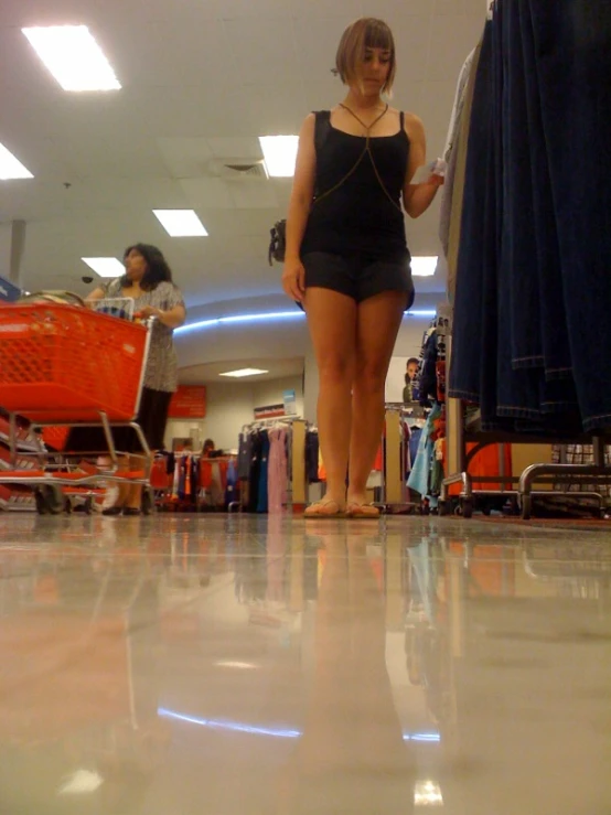 a woman in a black bathing suit is walking through the store