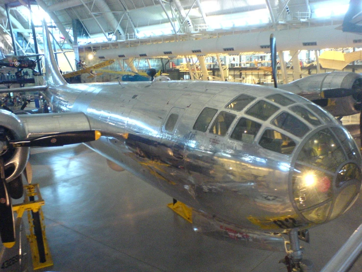 an airplane parked inside a garage under lots of maintenance tools